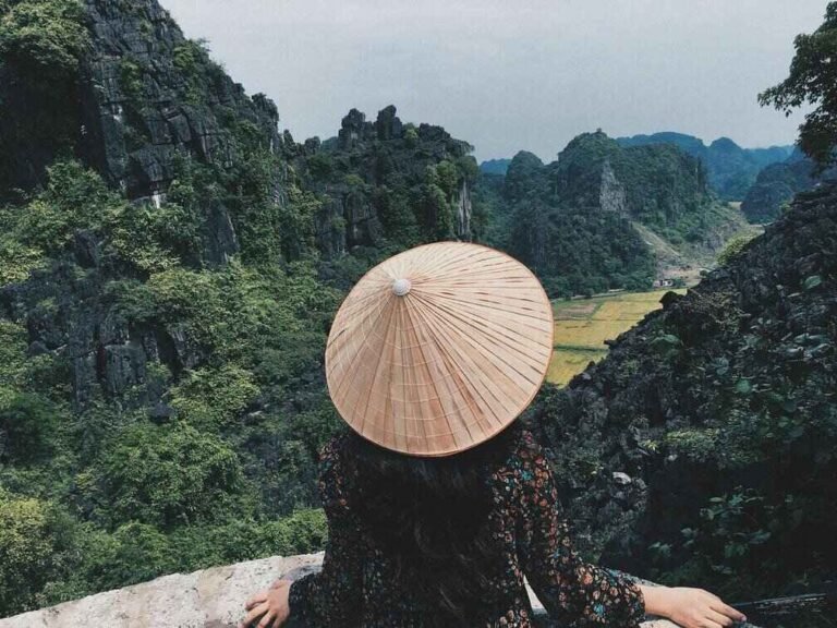 una ragazza di spalle che guarda le montagne