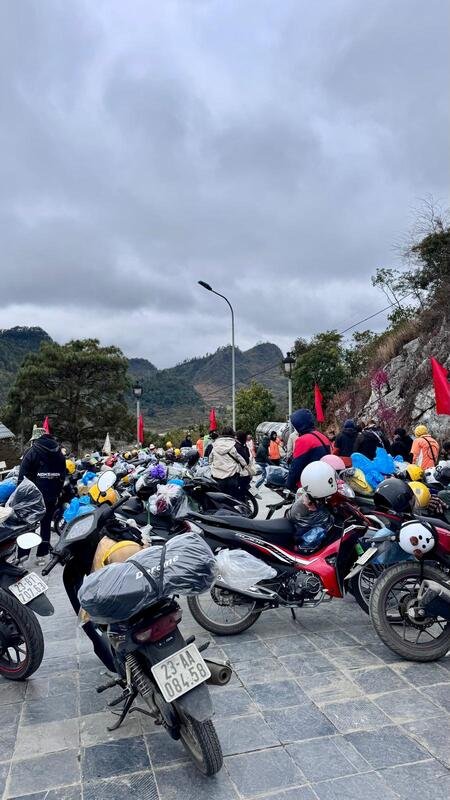 Motorini sotto la torre di Lũng Cú