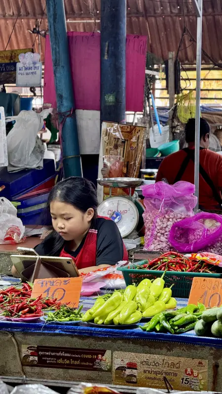 una ragazza che vende cibo in un mercato in Thailandia