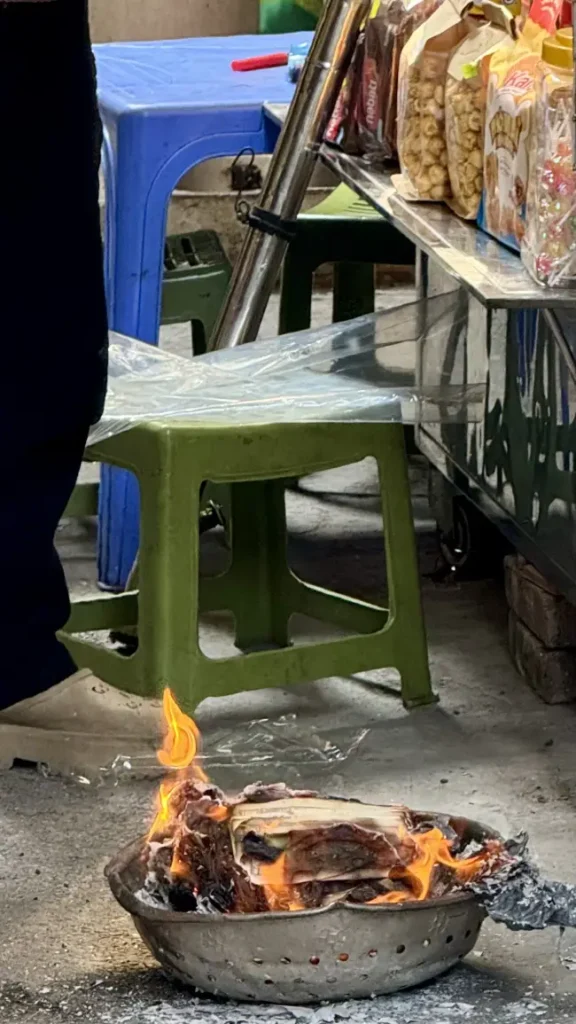 Scodella di latta che brucia in una strada ad Hanoi