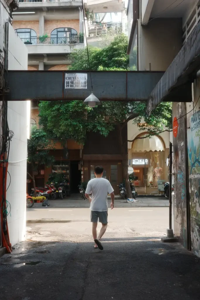 Vicolo di Ho Chi Minh City con un abitante diretto verso la strada